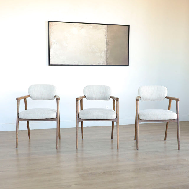 Lot de trois chaises style scandinave avec structure en bois et assise beige rembourree.