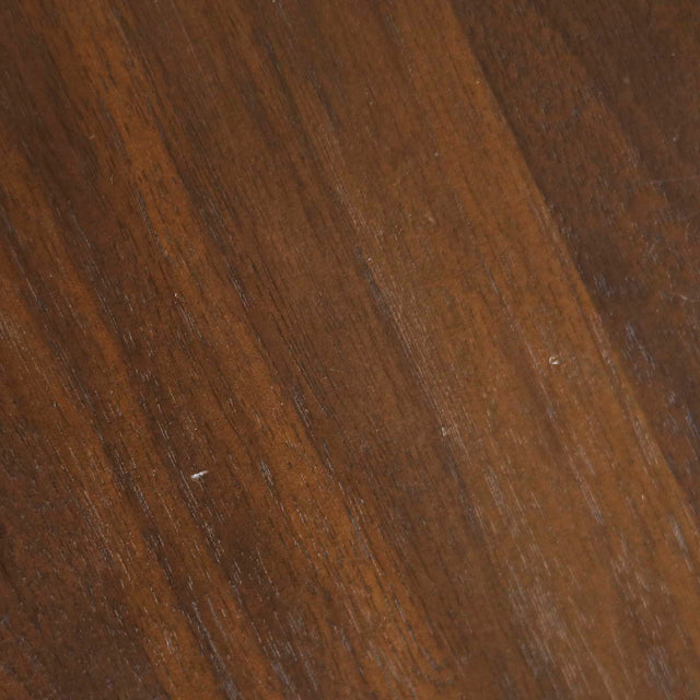 Image rapprochée d'une table ronde en noyer massif avec pied central croise au design contemporain.