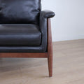 Fauteuil en cuir noir avec structure en bois style moderne.