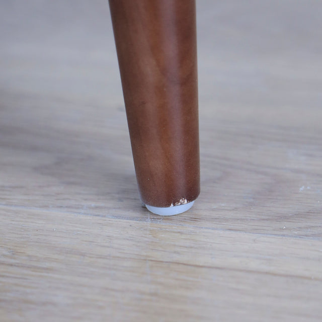 Image rapprochée d'une patte d'un Image rapprochée d'un Fauteuil en cuir noir avec structure en bois style moderne.