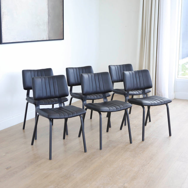 ensemble de chaises noires style vintage avec assise et dossier matelassé.