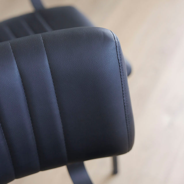 ensemble de chaises noires style vintage avec assise et dossier matelassé.