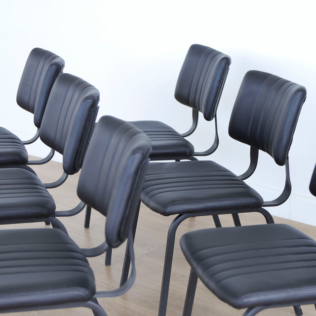 ensemble de chaises noires style vintage avec assise et dossier matelassé.