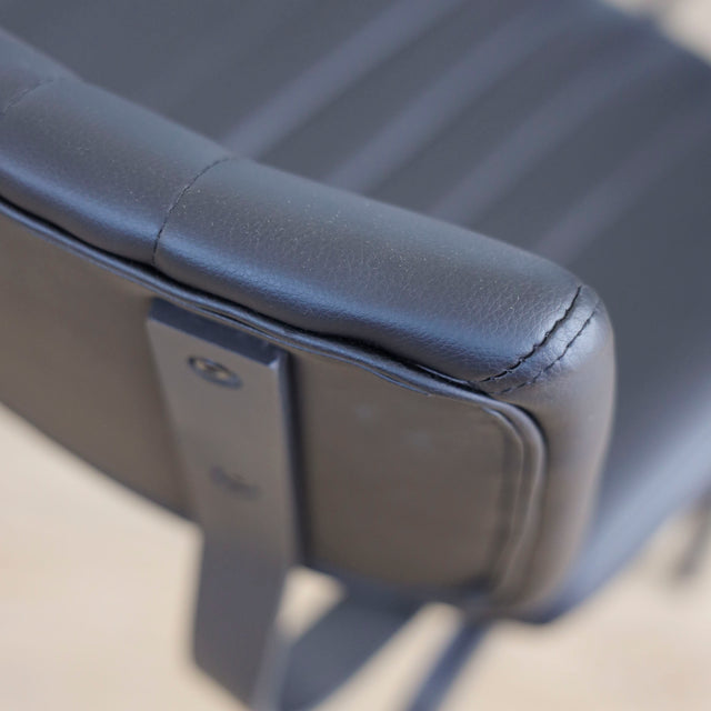 ensemble de chaises noires style vintage avec assise et dossier matelassé.