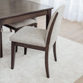 Table de salle à manger en bois foncé avec chaises rembourrées en tissu beige, style contemporain.