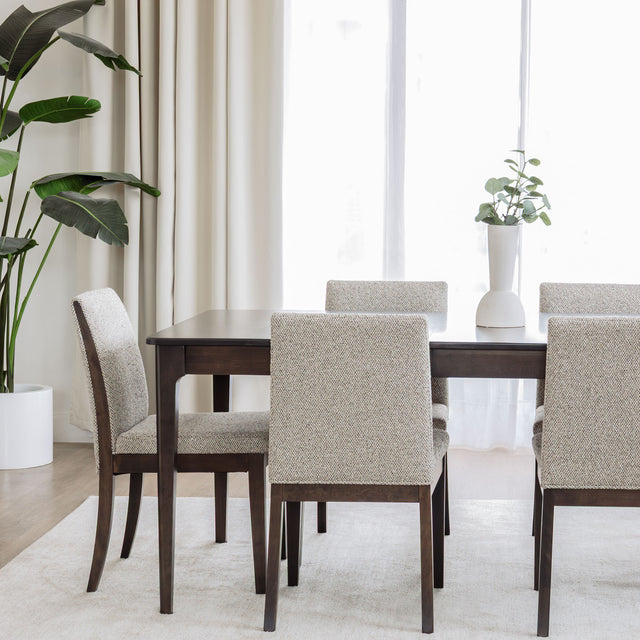 Table de salle à manger en bois foncé avec chaises rembourrées en tissu beige, style contemporain.
