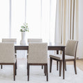 Table de salle à manger en bois foncé avec chaises rembourrées en tissu beige, style contemporain.