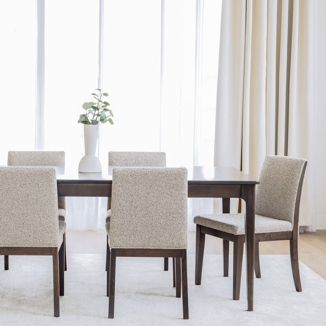 Table de salle à manger en bois foncé avec chaises rembourrées en tissu beige, style contemporain.