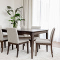 Table de salle à manger en bois foncé avec chaises rembourrées en tissu beige, style contemporain.