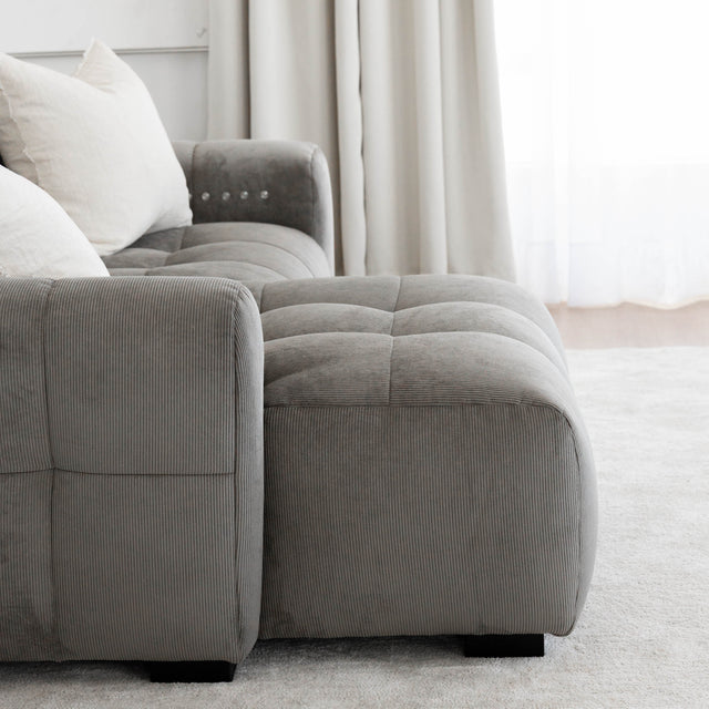 Sectionnel en velours côtelé brun avec assise profonde, design moderne dans un salon épuré.