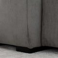 Sectionnel en velours côtelé brun avec assise profonde, design moderne dans un salon épuré.