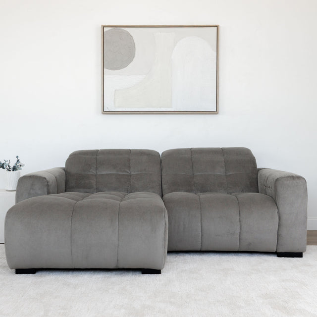 Sectionnel en velours côtelé brun avec assise profonde, design moderne dans un salon épuré.