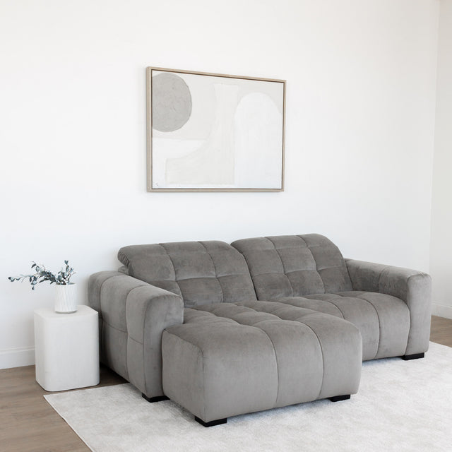 Sectionnel en velours côtelé brun avec assise profonde, design moderne dans un salon épuré.