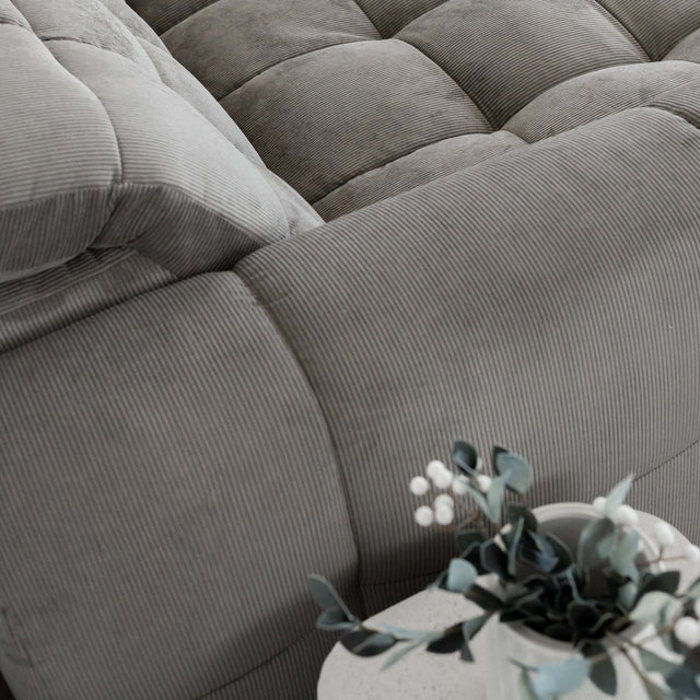 Sectionnel en velours côtelé brun avec assise profonde, design moderne dans un salon épuré.
