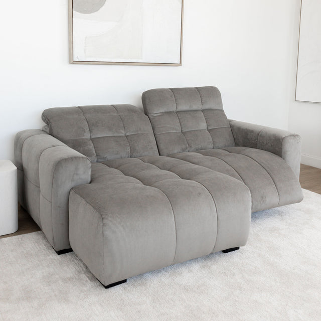 Sectionnel en velours côtelé brun avec assise profonde, design moderne dans un salon épuré.