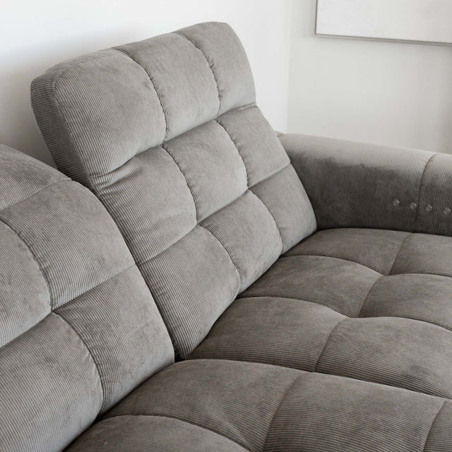 Sectionnel en velours côtelé brun avec assise profonde, design moderne dans un salon épuré.