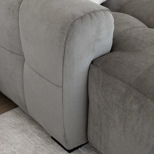 Sectionnel en velours côtelé brun avec assise profonde, design moderne dans un salon épuré.