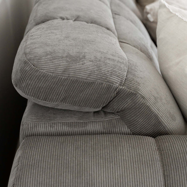 Sectionnel en velours côtelé brun avec assise profonde, design moderne dans un salon épuré.