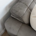 Sectionnel en velours côtelé brun avec assise profonde, design moderne dans un salon épuré.