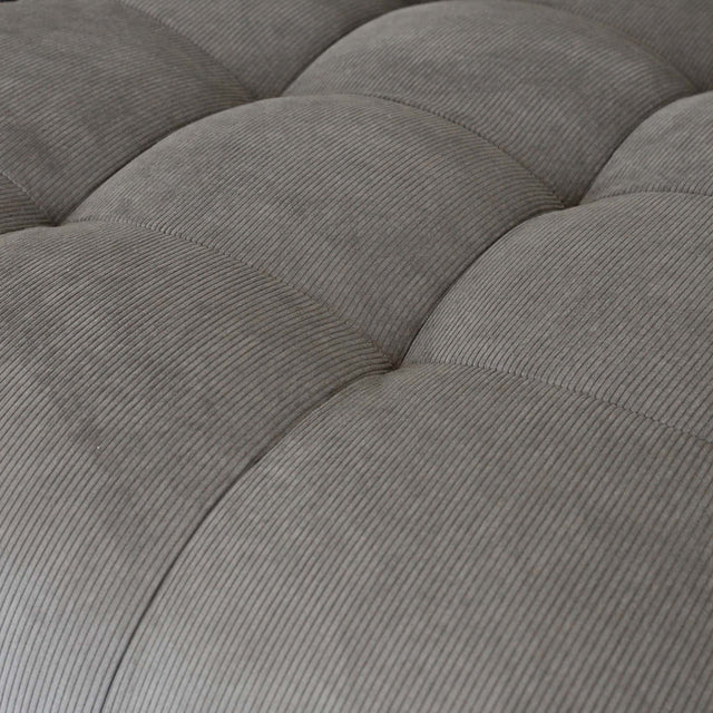 Sectionnel en velours côtelé brun avec assise profonde, design moderne dans un salon épuré.