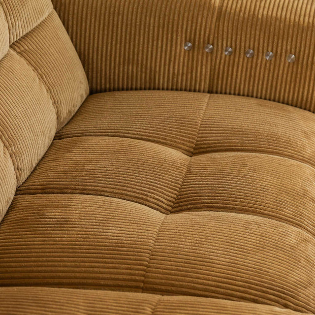 Sectionnel en velours côtelé camel, design moderne avec assise large dans un salon minimaliste.
