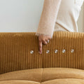 Sectionnel en velours côtelé camel, design moderne avec assise large dans un salon minimaliste.