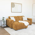 Sectionnel en velours côtelé camel, design moderne avec assise large dans un salon minimaliste.