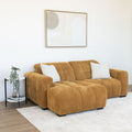 Sectionnel en velours côtelé camel, design moderne avec assise large dans un salon minimaliste.