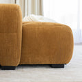 Sectionnel en velours côtelé camel, design moderne avec assise large dans un salon minimaliste.