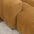 Sectionnel en velours côtelé camel, design moderne avec assise large dans un salon minimaliste.