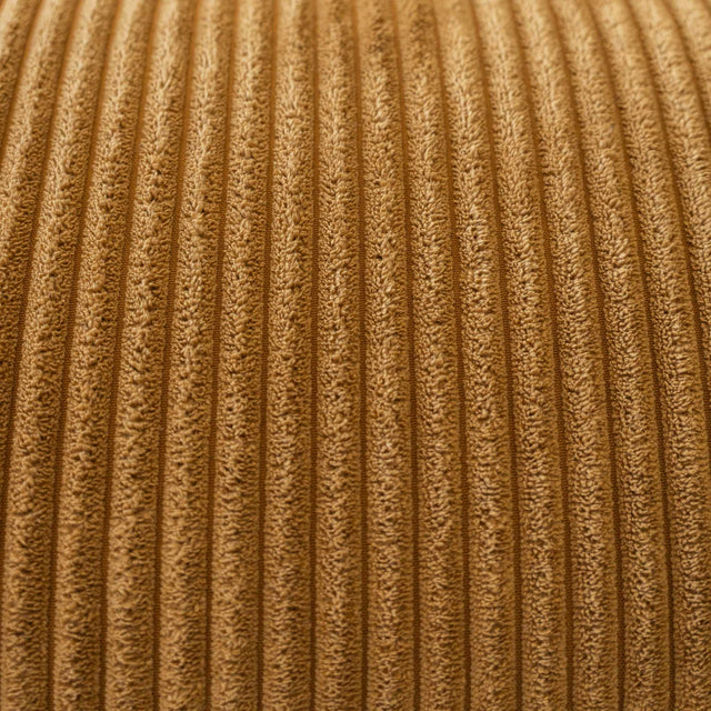 Sectionnel en velours côtelé camel, design moderne avec assise large dans un salon minimaliste.