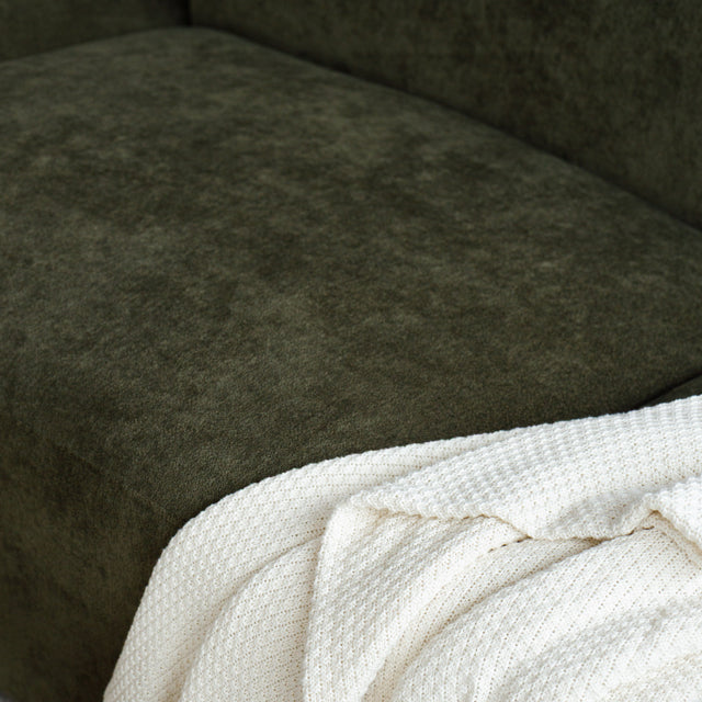 Sectionnel en tissu vert olive avec méridienne gauche, au design arrondi et contemporain dans un salon lumineux.