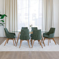 Chaise de salle à manger en tissu vert avec accoudoirs et pieds en bois, style moderne autour d’une table en verre.