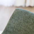 Chaise de salle à manger en tissu vert avec accoudoirs et pieds en bois, style moderne autour d’une table en verre.