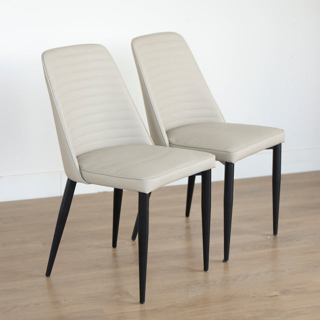 Deux chaises modernes taupe avec pieds noirs coniques, design elegant pour salle a manger.