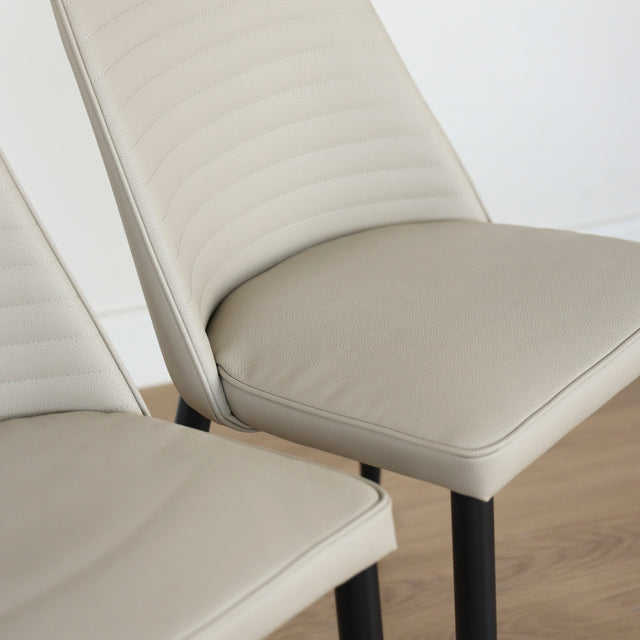 Deux chaises modernes taupe avec pieds noirs coniques, design elegant pour salle a manger.