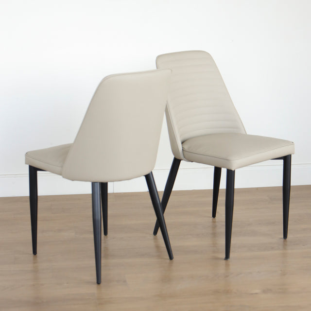 Deux chaises modernes taupe avec pieds noirs coniques, design elegant pour salle a manger.