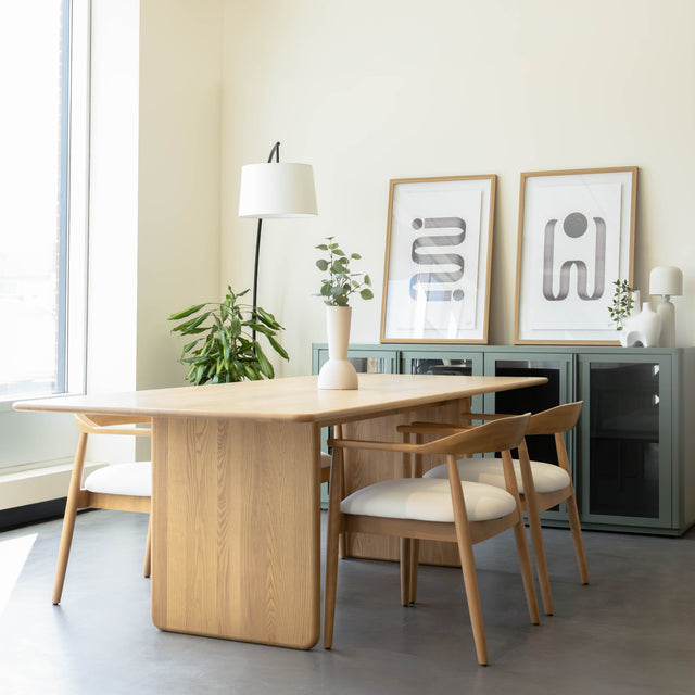 Table de salle à manger en chêne clair avec chaises assorties et buffet moderne dans un intérieur scandinave lumineux.