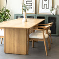Table de salle à manger en chêne clair avec chaises assorties et buffet moderne dans un intérieur scandinave lumineux.