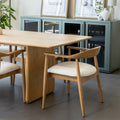 Table de salle à manger en chêne clair avec chaises assorties et buffet moderne dans un intérieur scandinave lumineux.
