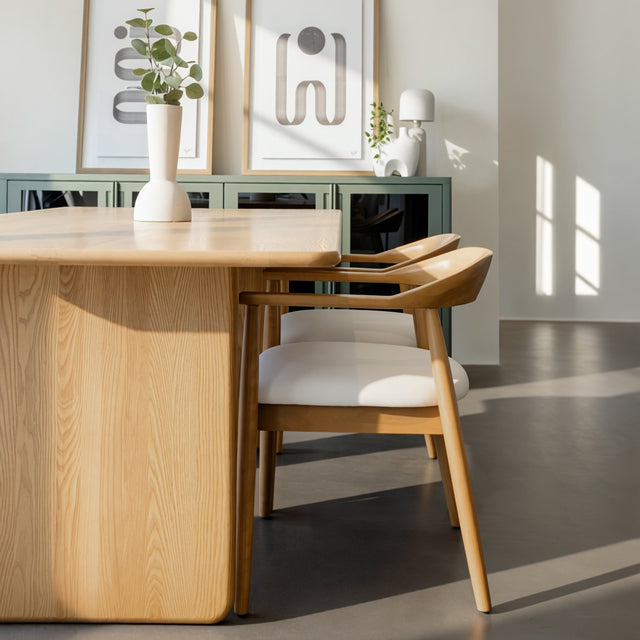 Table de salle à manger en chêne clair avec chaises assorties et buffet moderne dans un intérieur scandinave lumineux.
