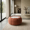 Ottoman rond terracotta avec plateau central, design moderne multifonction dans un salon lumineux.