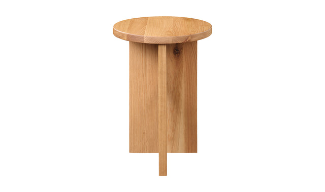 Table d'appoint en bois clair au design minimaliste pose sur tapis texture dans un interieur moderne.