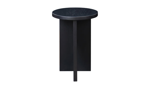 Table d'appoint en bois noir au design minimaliste pose sur tapis texture dans un interieur moderne.