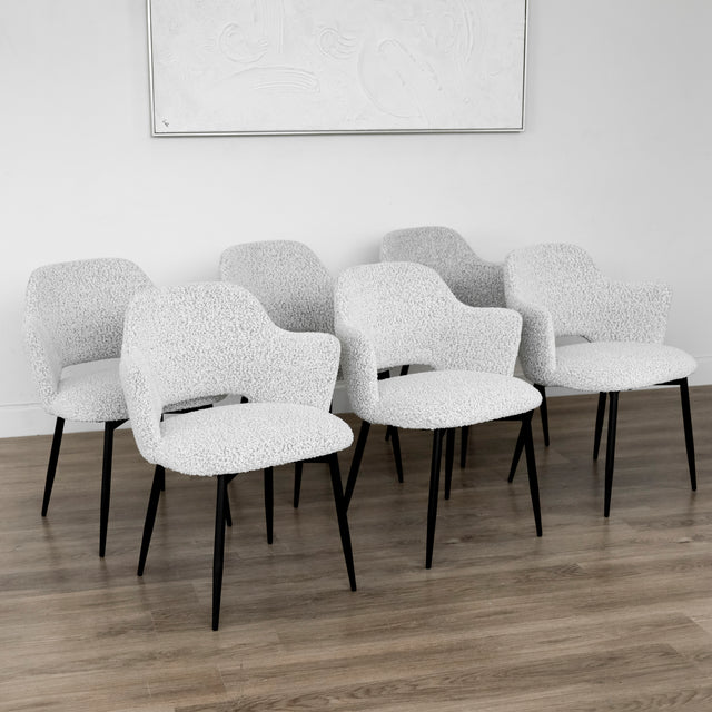 Lot de six chaises modernes en tissu boucle blanc avec pieds noirs elegants.