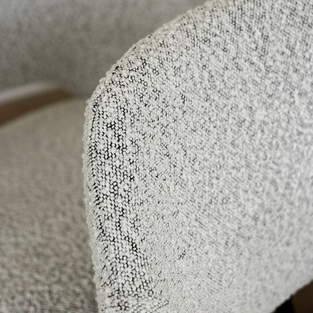 Image rapprochée lot de six chaises modernes en tissu boucle blanc avec pieds noirs elegants.