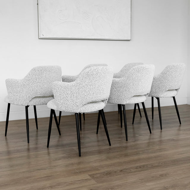 Lot de six chaises modernes en tissu boucle blanc avec pieds noirs elegants.
