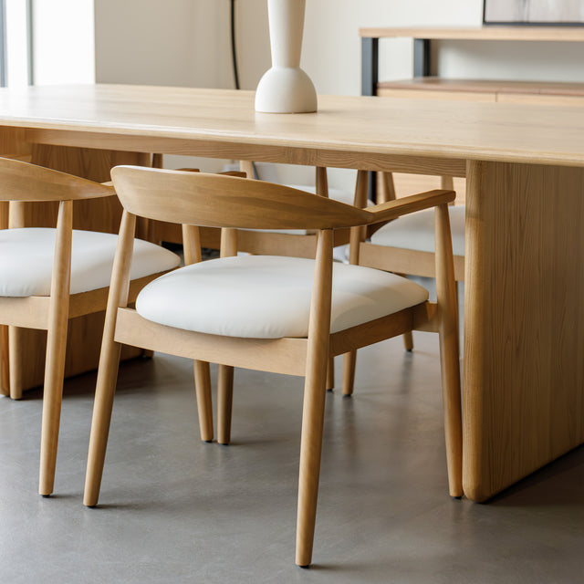Chaise de cuisine en bois merisier avec assise rembourrée cuir végane beige style scandinave.