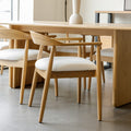 Chaise de cuisine en bois merisier avec assise rembourrée cuir végane beige style scandinave.