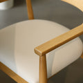 Chaise de cuisine en bois merisier avec assise rembourrée cuir végane beige style scandinave.